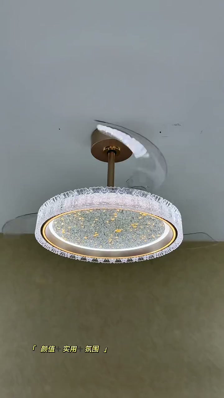 A round ceiling fan light with a rippled rim, bright inner ring, speckled underside, and curved blades above, viewed from below.